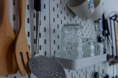 a kitchen rack with a glass jar and utensils at Central Garden Studio in Ljubljana