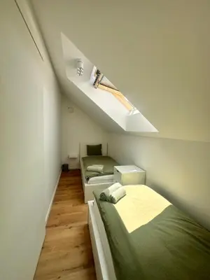 a attic bedroom with two beds and a sloped ceiling at Sitara's Chalet in Bled
