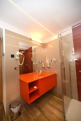 a bathroom with an orange sink and a shower at Fedrig Hostel rooms Apartment for 10 in Kobarid