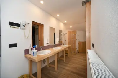 a bathroom with two sinks and a large mirror at Fedrig Hostel rooms Apartment for 10 in Kobarid