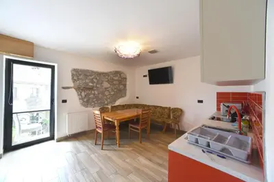 a kitchen and dining room with a table and chairs at Fedrig Hostel rooms Apartment for 10 in Kobarid