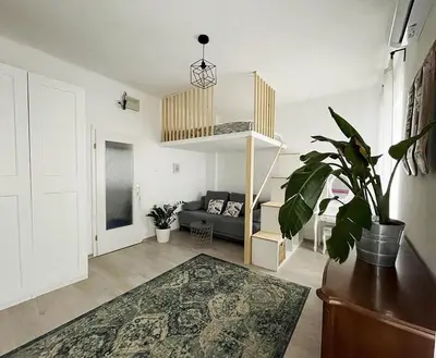 a living room with a couch and a potted plant at Manca's Apartment with Free Parking in Ljubljana
