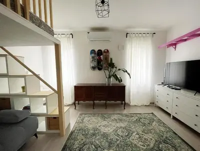 a living room with a bed and a couch and a television at Manca's Apartment with Free Parking in Ljubljana