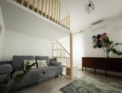 a living room with a blue couch and a staircase at Manca's Apartment with Free Parking in Ljubljana