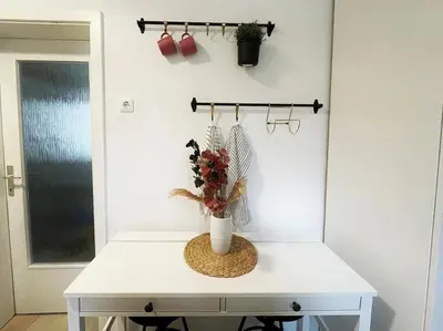 a white table with a vase of flowers on it at Manca's Apartment with Free Parking in Ljubljana