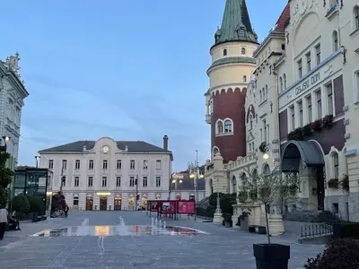 a city street with buildings and a clock tower at Celje Spa Apartment in Celje