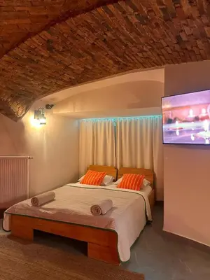 a bedroom with a bed with a tv on the wall at Celje Spa Apartment in Celje