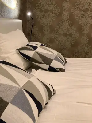 a bed with two pillows and a lamp on it at Apartment Center in Bled