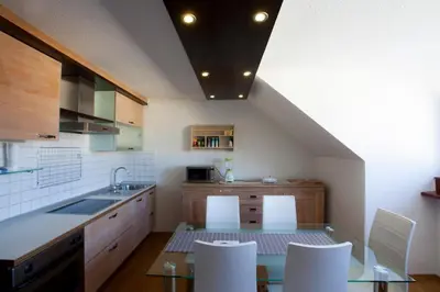 a kitchen with a table and some white chairs at Apartment Center in Bled