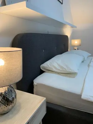 a bedroom with a bed and a table with a lamp at Apartment Center in Bled
