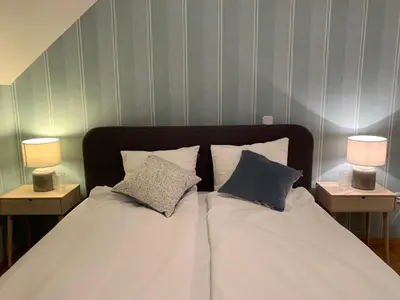 a bed with two pillows on it with two lamps at Apartment Center in Bled