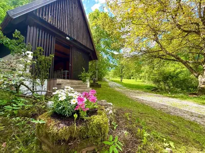 a small house with flowers in front of it at Soča Village in Soča