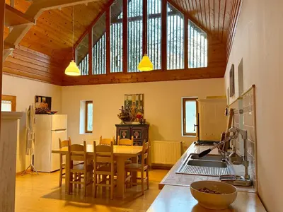 a kitchen with a table and chairs in a room at Soča Village in Soča