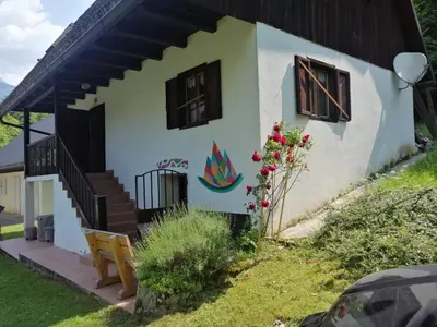 a small white house with a staircase and windows at Soča Village in Soča