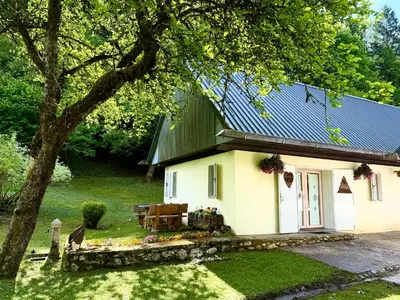 a small white house with a green roof at Soča Village in Soča