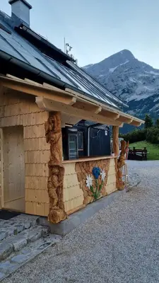a house with a building with a window on it at Poštarski dom on Vršič in Kranjska Gora