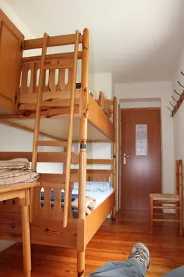a person laying on the floor in a room with bunk beds at Poštarski dom on Vršič in Kranjska Gora