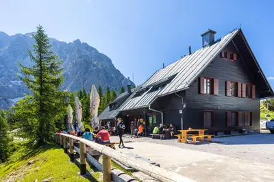 a group of people sitting outside of a building at Poštarski dom on Vršič in Kranjska Gora