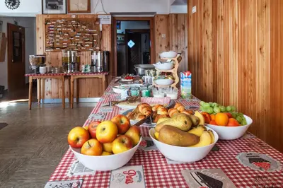 a table with bowls of fruit on a red and white table cloth at Poštarski dom on Vršič in Kranjska Gora