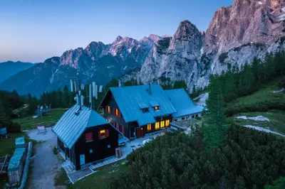 an aerial view of a house with mountains in the background at Poštarski dom on Vršič in Kranjska Gora