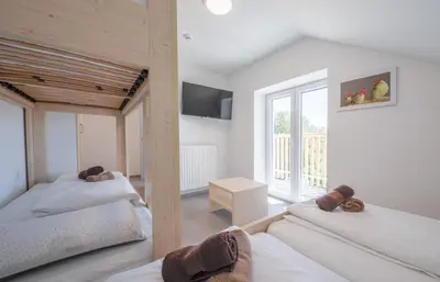 a bedroom with two beds and a balcony at Tončkov dom na Lisci in Sevnica