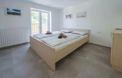 a large bed in a room with a large window at Tončkov dom na Lisci in Sevnica