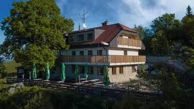 a large building with green umbrellas in front of it at Tončkov dom na Lisci in Sevnica
