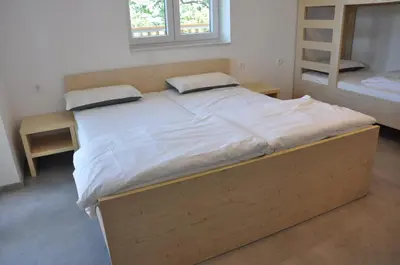 a large bed in a room with two bunk beds at Tončkov dom na Lisci in Sevnica