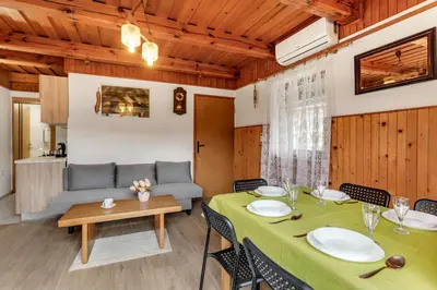 a dining room with a table and a couch at Urban Escape Cottage in Ljutomer