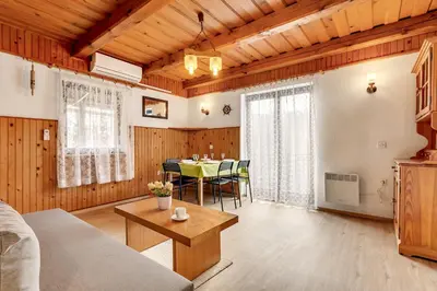 a living room with a table and a dining room at Urban Escape Cottage in Ljutomer