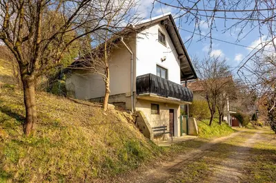 a house on a hill next to a dirt road at Urban Escape Cottage in Ljutomer