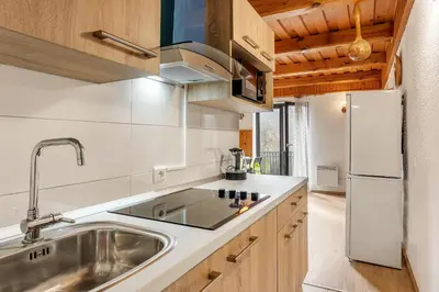 a kitchen with a sink and a refrigerator at Urban Escape Cottage in Ljutomer