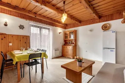 a kitchen and dining room with a table and chairs at Urban Escape Cottage in Ljutomer