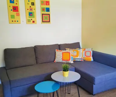 a blue couch with two tables in a living room at Apartments Grudnik in Kranjska Gora