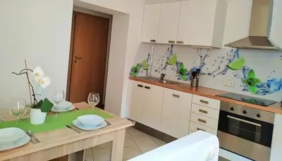 a kitchen with a table with wine glasses on it at Apartments Grudnik in Kranjska Gora
