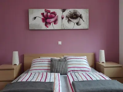 a bedroom with two beds and a painting on the wall at Apartments Grudnik in Kranjska Gora
