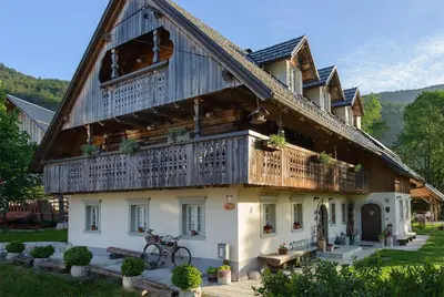 a large wooden house with a balcony at Rustic House 13 in Bohinj