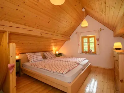a bedroom with a large bed in a wooden ceiling at Rustic House 13 in Bohinj