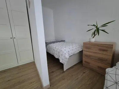 a small bedroom with a bed and a potted plant at Holiday Home Mila in Spodnja Idrija