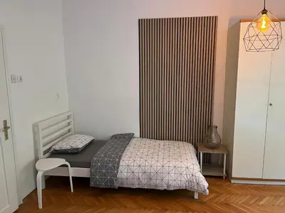 a bedroom with a bed and a chair in it at Holiday Home Mila in Spodnja Idrija