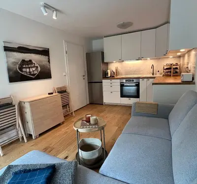 a living room with a couch and a kitchen at Cosy getaway in raw nature in Šentjur