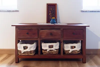 a wooden dresser with baskets on the shelves at Apartment Grič with Sauna in Stari Trg pri Ložu