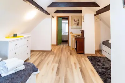 a attic bedroom with a bed and a dresser at Apartment Grič with Sauna in Stari Trg pri Ložu