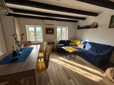 a living room with a blue couch and a table at Apartment Grič with Sauna in Stari Trg pri Ložu