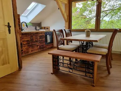 a kitchen with a table and chairs and a sink at Studio Apartma2 pri Adamu in Mislinja
