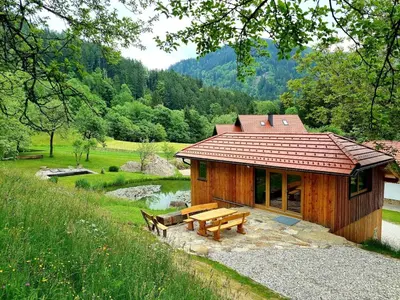 a log cabin with a picnic table and a pond at Studio Apartma2 pri Adamu in Mislinja