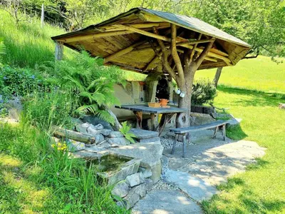 a picnic shelter with a table and a bench at Studio Apartma2 pri Adamu in Mislinja