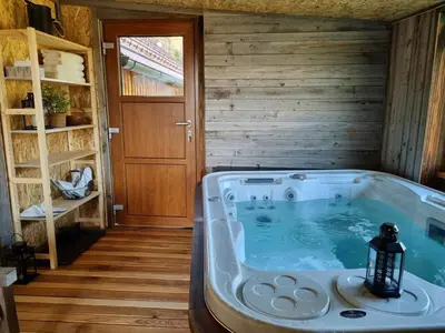 a jacuzzi tub in a room with wooden walls at Studio Apartma2 pri Adamu in Mislinja
