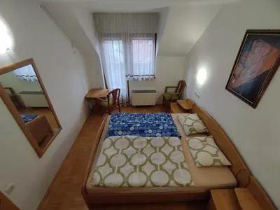 a small room with a bed and a mirror at Apartma Valerija in Zreče