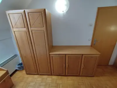 a room with a wooden cabinet and a closet at Apartma Valerija in Zreče
